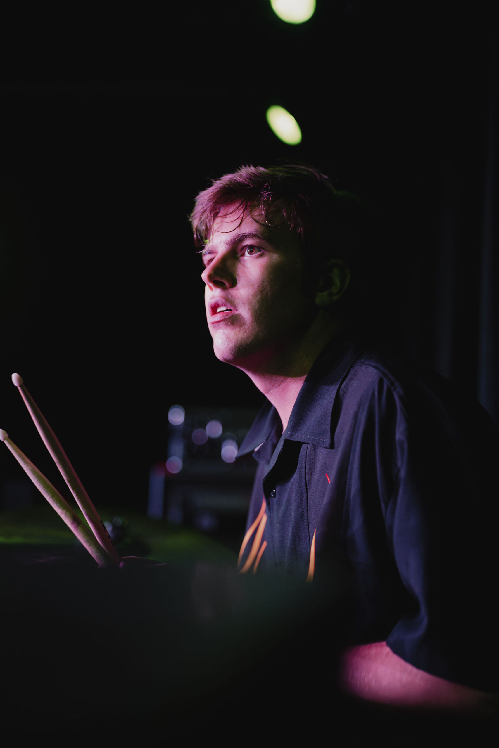 An image of a drummer looking forward right before a concert starts