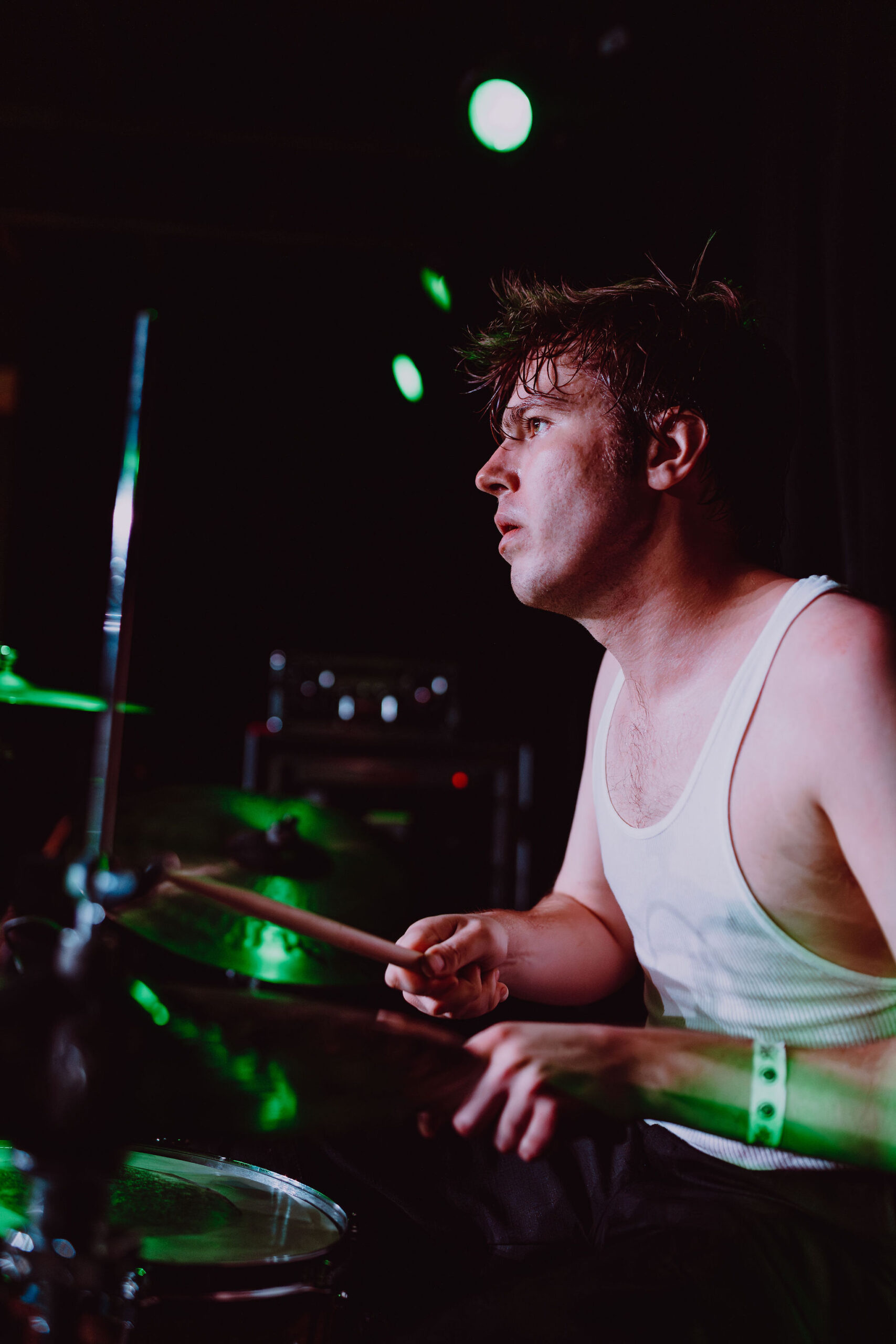 A male drummer warming up with a dark background