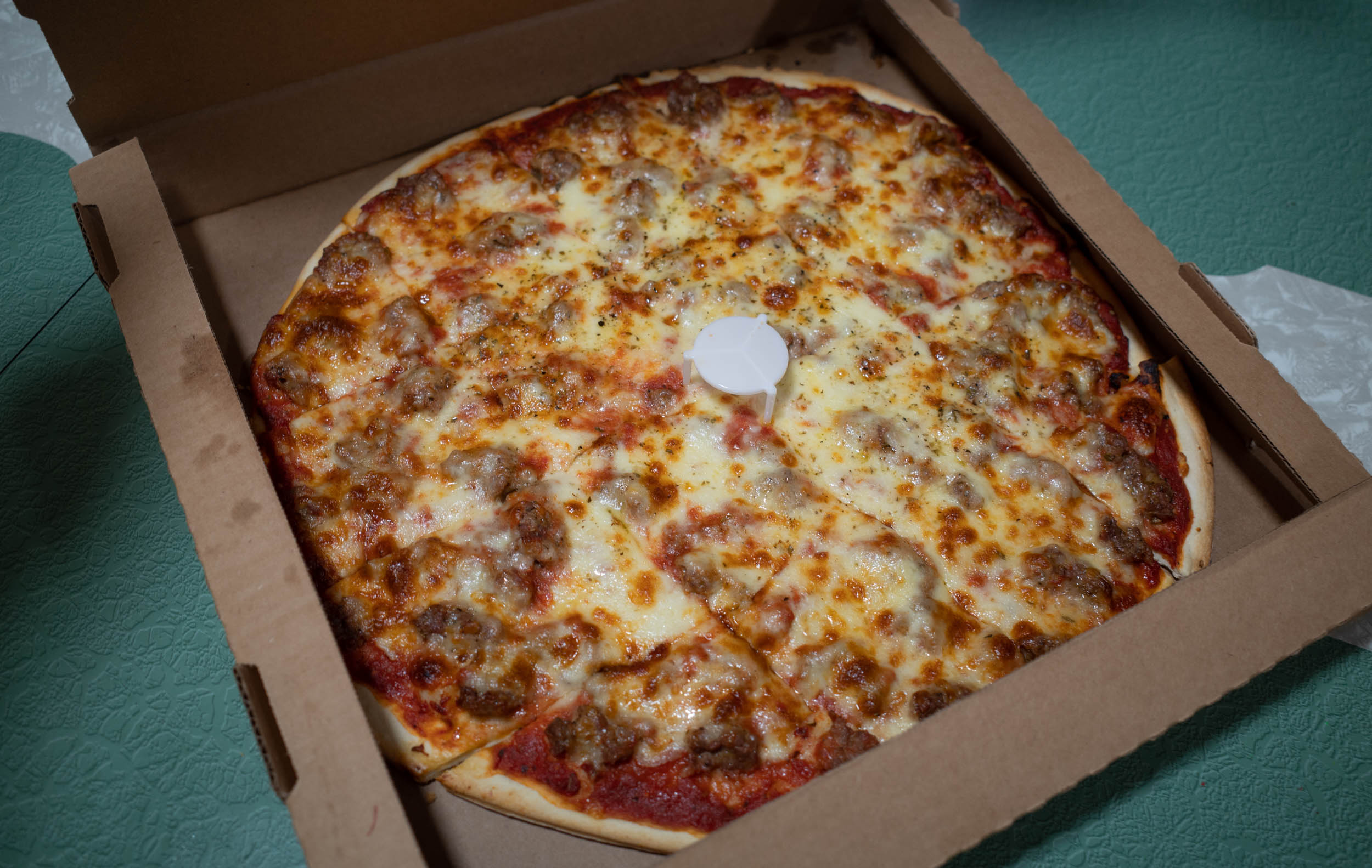 chicago thin crust sausage pizza in an open box 