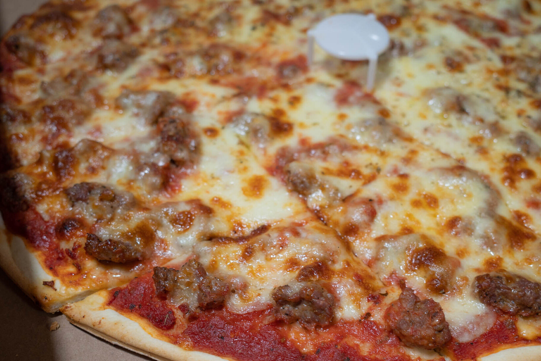 close up sausage pizza in a box 