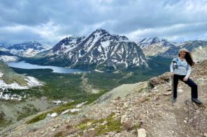 woman hiking with mountain and lake in the dsitance at glacier national park