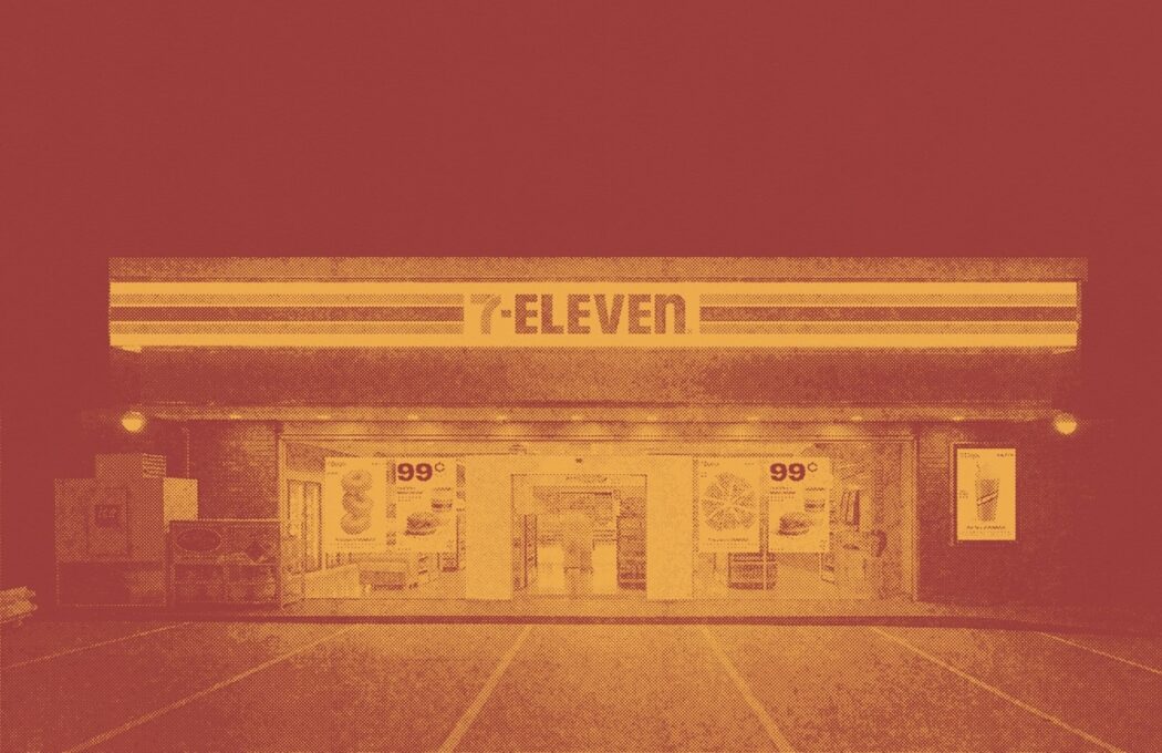 A grainy image of a 7-eleven storefront. There is a yellowish light to it and the background is red.